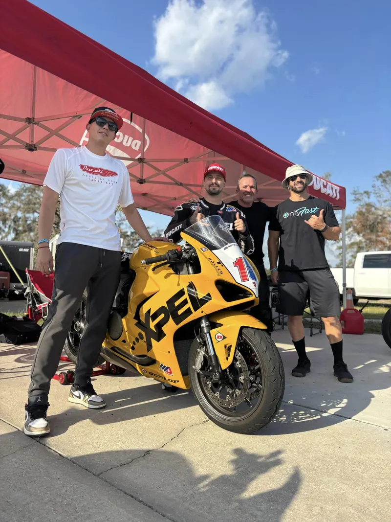 PJ Jacobsen with a group of riders and a yellow track bike at Jennings GP